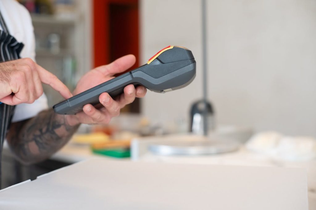 Restaurant staff using a modern wireless POS terminal for transactions.